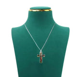 Cross pendant necklace on a green mannequin bust with a white background